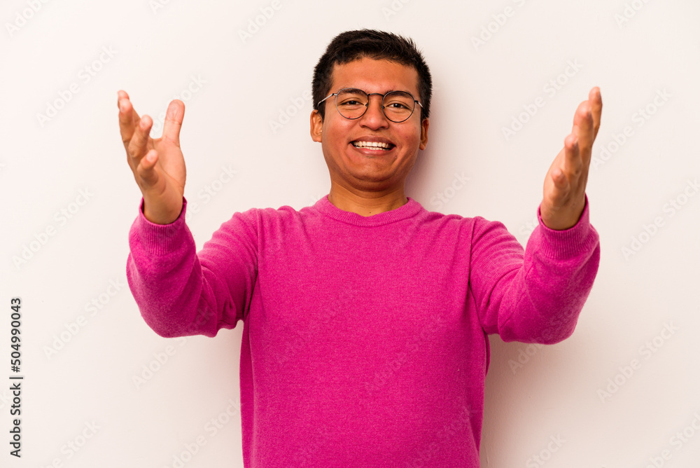 Fototapeta premium Young hispanic man isolated on white background celebrating a victory or success, he is surprised and shocked.