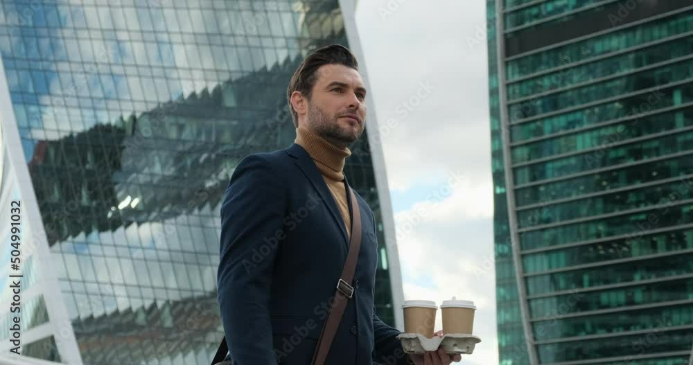 stylish man in suit and turtleneck with coffee. serious pensive director of prosperous company enjoying cup of coffee in the morning near the office center in the business district. stylish man in suit and turtleneck with coffee. serious pensive director of prosperous company enjoying cup of coffee in the morning near the office center in the business district.