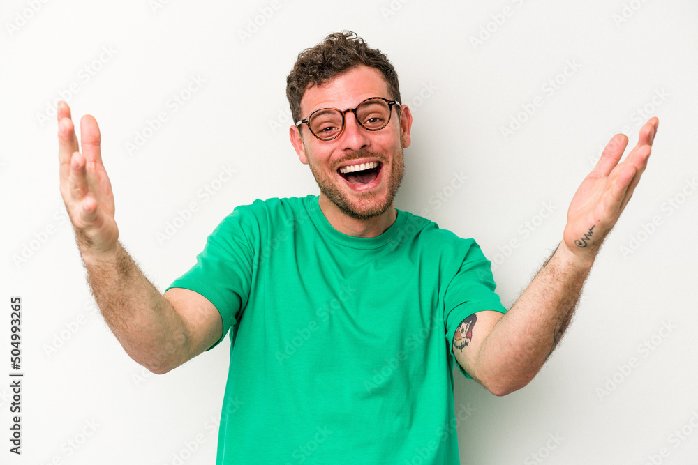 Young caucasian man isolated on white background celebrating a victory or success, he is surprised and shocked.