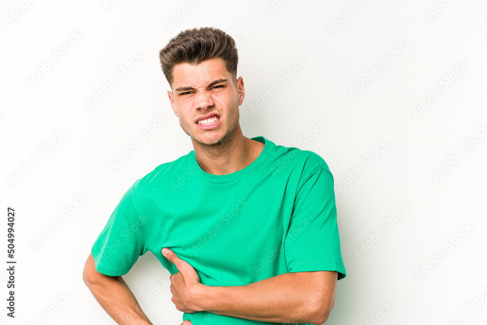 Fototapeta premium Young caucasian man isolated on white background having a liver pain, stomach ache.