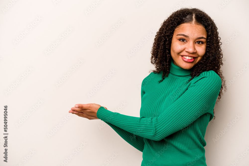 Young African American woman isolated on white background holding a copy space on a palm. Young African American woman isolated on white background holding a copy space on a palm.