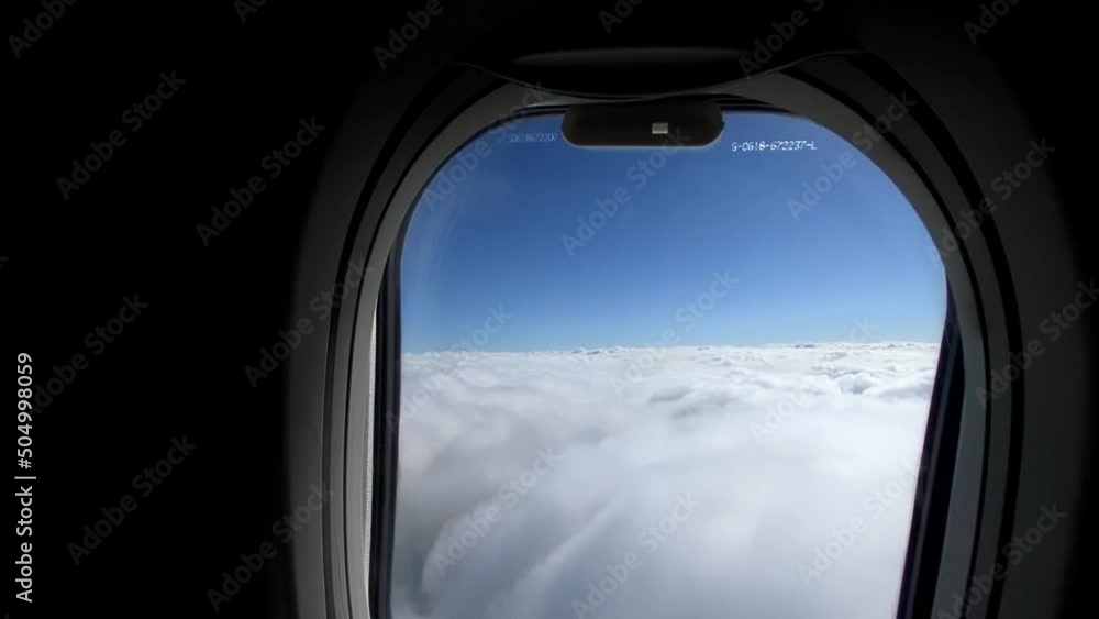 plane flies over fluffy white clouds in the stratosphere. view from inside the plane. plane flies over fluffy white clouds in the stratosphere. view from inside the plane.
