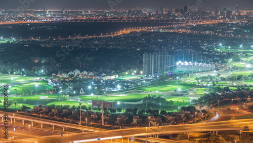 Aerial view to Golf course with green lawn and lakes, villa houses behind it night timelapse.