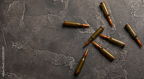 Bullets on black textured marble. Bullets of a kolashnikov assault rifle close-up with space for text. Cartridges for a rifle and a carbine on a wooden background. Military concept. copy space photo