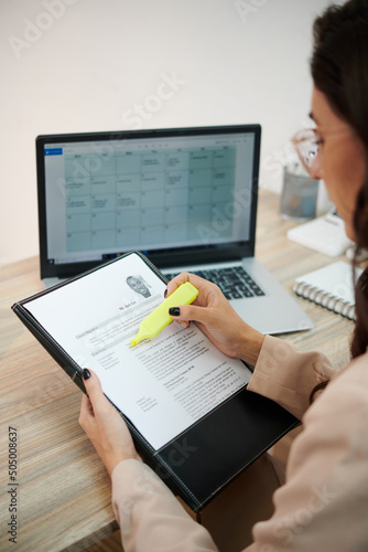 Fotografía HR manager reading cv of candidate and highlighting important details
