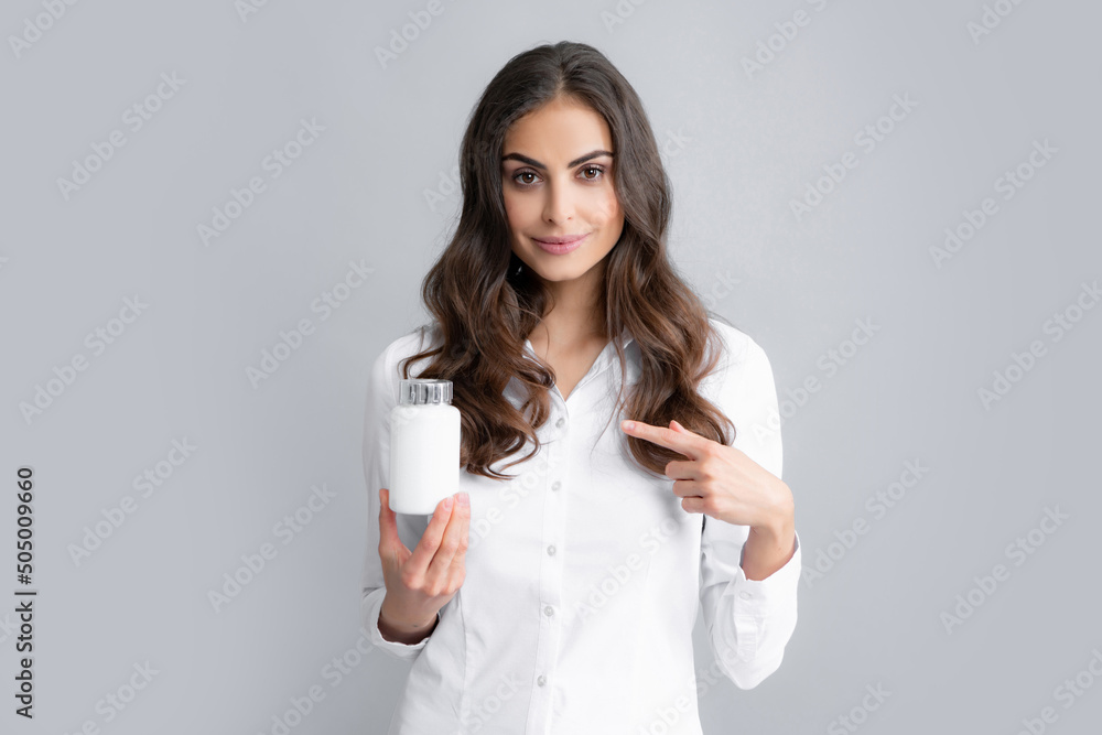 Healthcare and medicine. Portrait of attractive girl holding on bottle pills healthy product over gray background. Healthcare and medicine. Portrait of attractive girl holding on bottle pills healthy product over gray background.