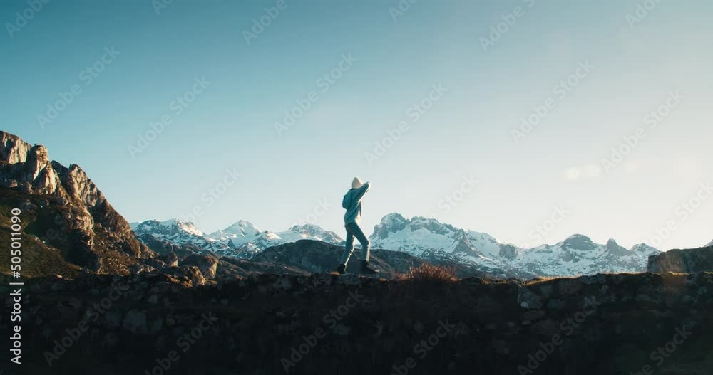 custom made wallpaper toronto digitalExcited young woman on travel adventure crossing old rock bridge with epic mountain views. Traveler on hike trip walk with snowed mountain peaks as on background. Road trip wanderlust