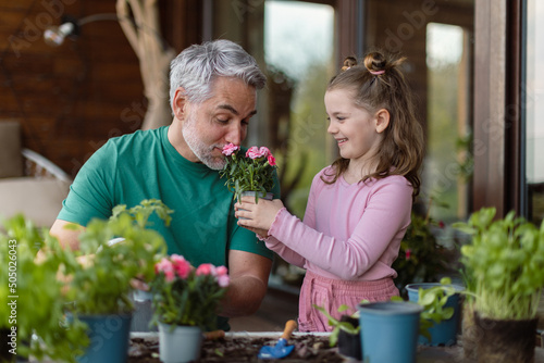 Little daughter helping father to plant flowers, home gardening concept © Halfpoint