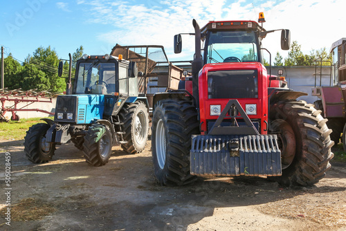 Agricultural machinery  tractors and equipment outdoors  near the garage  ready to work in the field.