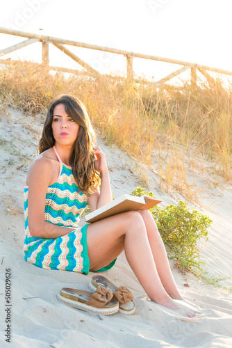 Bella mujer disfrutando de una lectura relajante  junto al mar.