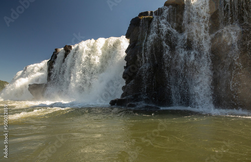 Sailing the river. The majestic Mocona waterfalls seen from the boat. The falling white water, rocks and river flowing across the jungle.