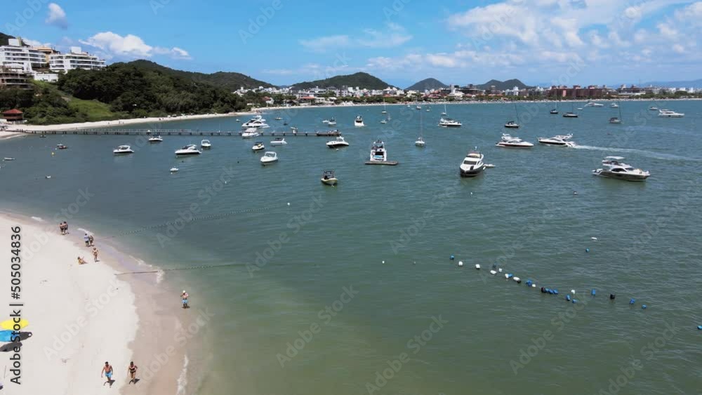 Aerial drone image of tropical beach with many people on the sand with boats and yachts sailing in the sea people enjoying the beach with sails near the shore trapuche pier of boats on the beach Aerial drone image of tropical beach with many people on the sand with boats and yachts sailing in the sea people enjoying the beach with sails near the shore trapuche pier of boats on the beach