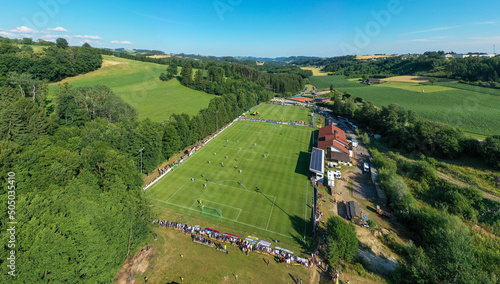 Drone view of a mountain landscape in Austria with a football field. Football pitch among fields and alpine mountains photo