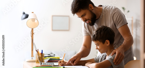Father helping his little s...