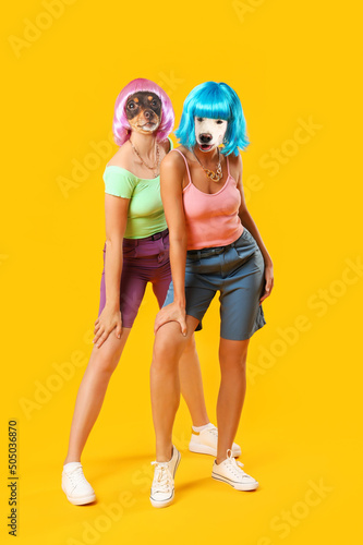 Fashionable dogs with human bodies on yellow background