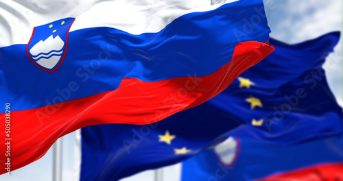 Detail of the national flag of Slovenia waving in the wind with blurred european union flag photo