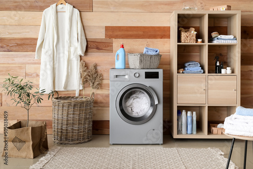 Interior of home laundry room with modern washing machine photo