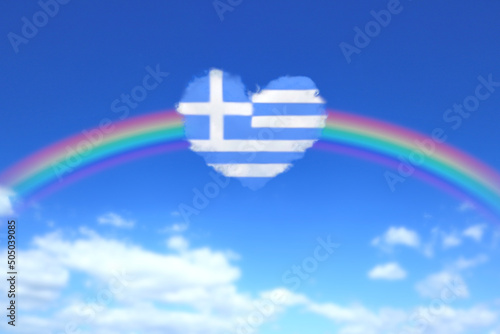 大きな虹とギリシャの国旗のようなハート形の雲が浮かぶ青空