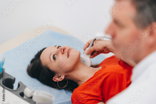 The woman makes an ultrasound examination of the neck.