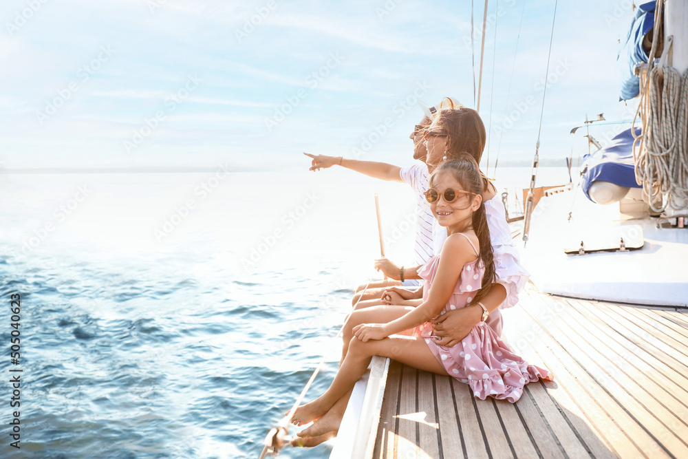 Happy young family resting on yacht - obrazy, fototapety, plakaty 