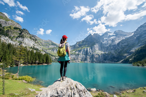 Young woman hiking near Oeschinensee (Oeschinen Lake) in summer, Kandersteg, Switzerland