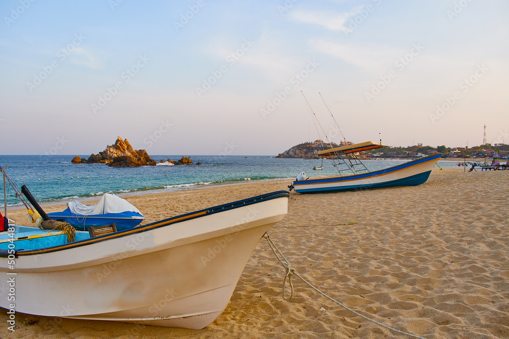 Landscape of the bay of San Agustin in Oaxaca Mexico. Huatulco beaches, paradisiacal beach. Fisherman's boats on the sand. Trunk of San Agustín Huatulco. Sunset on Mexican beaches. Landscape of the bay of San Agustin in Oaxaca Mexico. Huatulco beaches, paradisiacal beach. Fisherman's boats on the sand. Trunk of San Agustín Huatulco. Sunset on Mexican beaches.