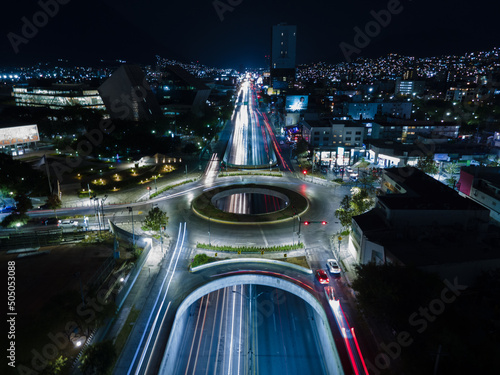 Obraz na płótnie urban night view of an avenue in the middle of a city at night, with cars on the