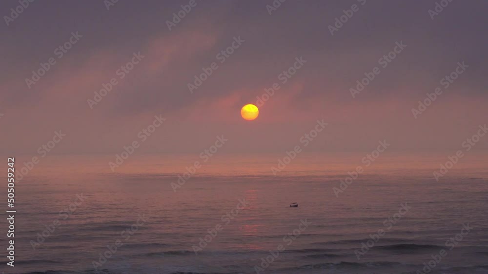quick camera of a beautiful sunset with the round yellow sun on the horizon until it hides among the clouds with a small boat in the sea. time lapse in 4k quick camera of a beautiful sunset with the round yellow sun on the horizon until it hides among the clouds with a small boat in the sea. time lapse in 4k