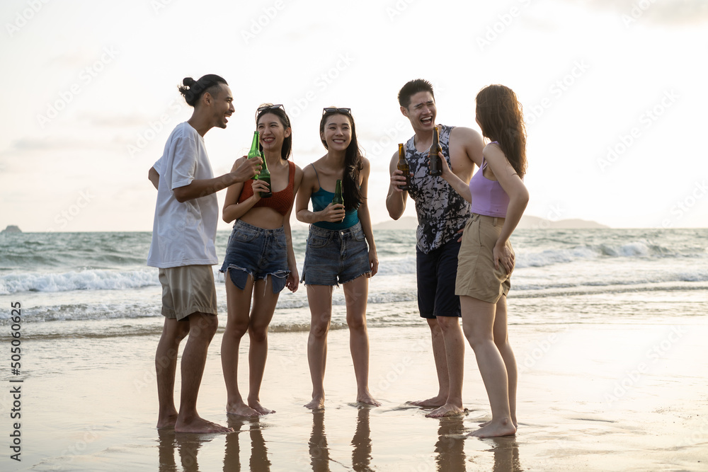 Group of Asian young man and woman having party on the beach together. 