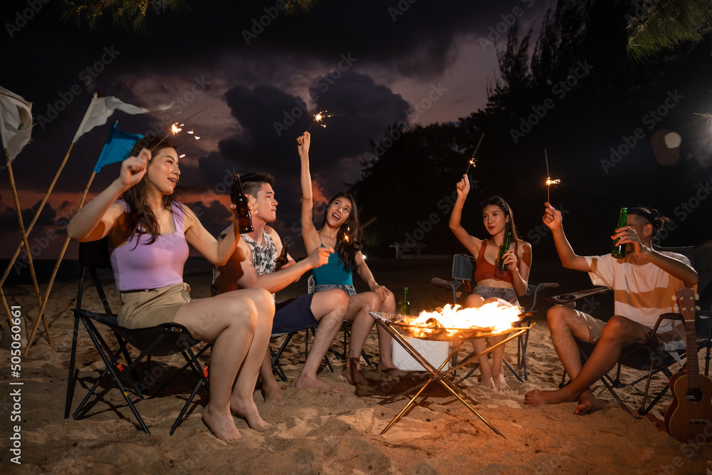 Φωτογραφία Group of Asian young man and woman having party on the beach at night