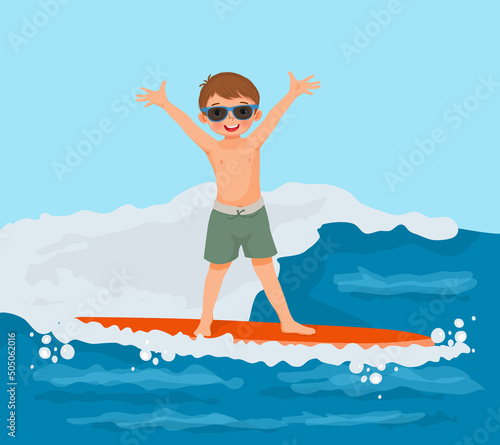 Cute little boy surfer with sunglasses waving hand riding on surfboard on sea wave on the beach in summertime