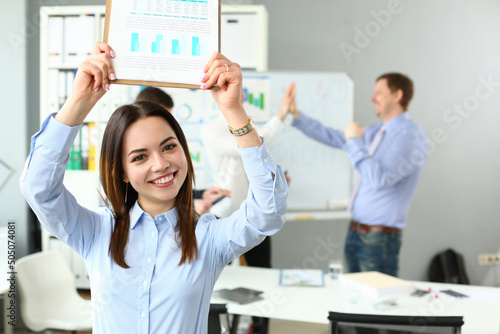 Woman lift document over head, celebrate good deal, beneficial agreement