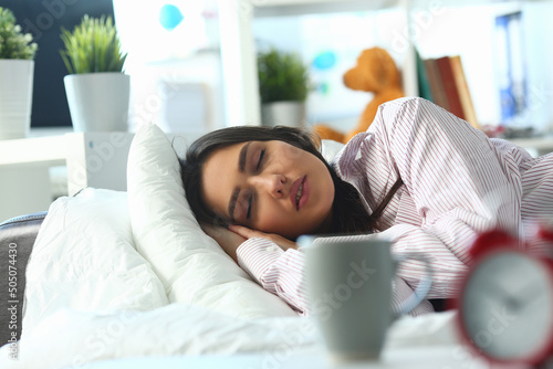 Young woman peacefully sleeping in bed, tired female, tough night, sleepless photo