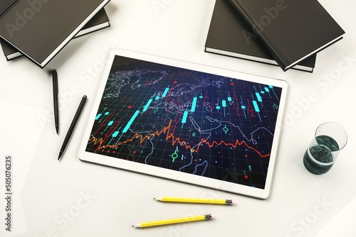 Modern digital tablet display with abstract creative financial chart and world map, research and analytics concept. Top view. 3D Rendering