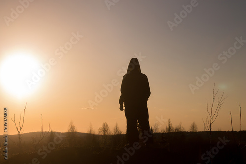 silhouette of a person standing on a hill