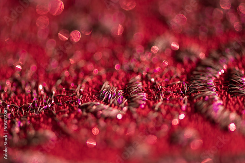 red background closeup macro of fabric and shiny thread photo