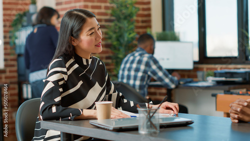 Asian employee greeting african american woman at job interview, talking about application. People meeting to discuss about employment offer and career opportunity, HR recruitment. photo