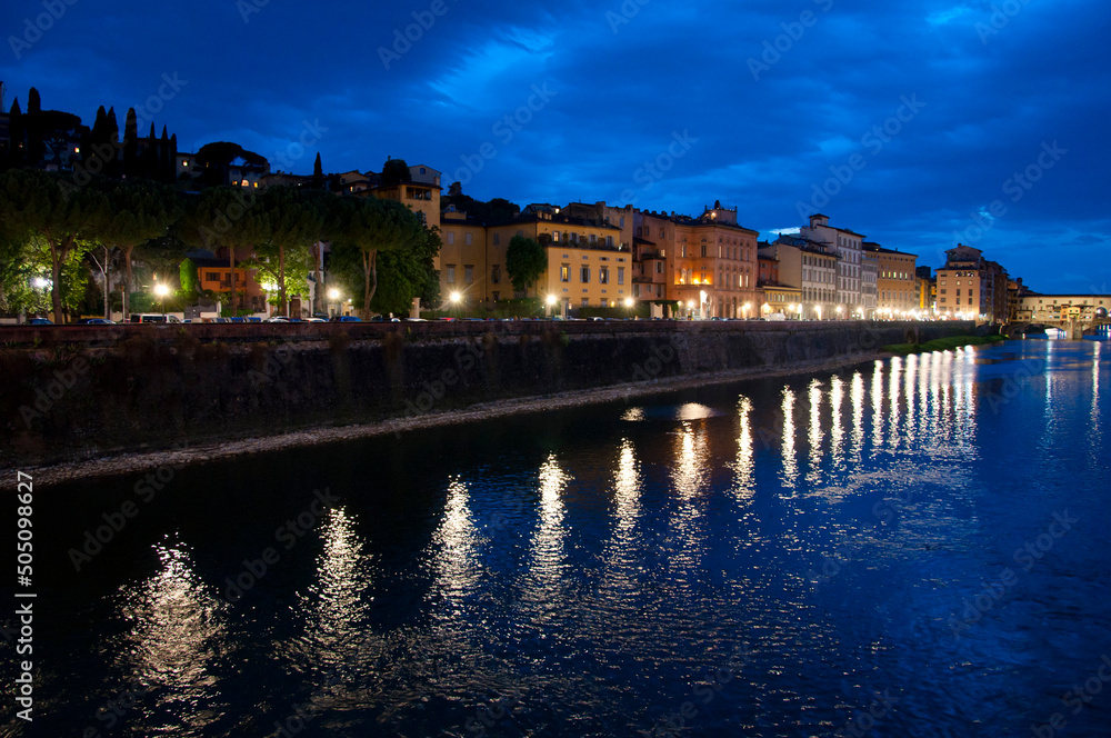 Arno river embankment with Ponte Vecchio bridge at night in Italy