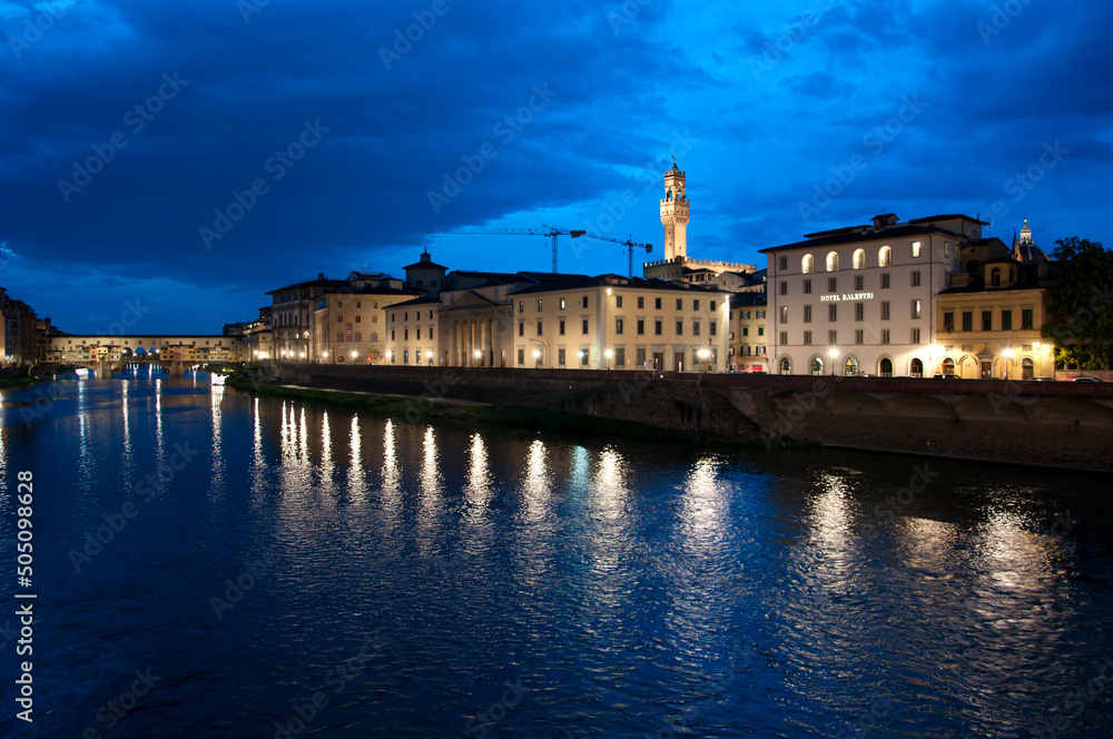 Florence waterfront with Ponte Vecchio bridge over Arno river at night in Italy