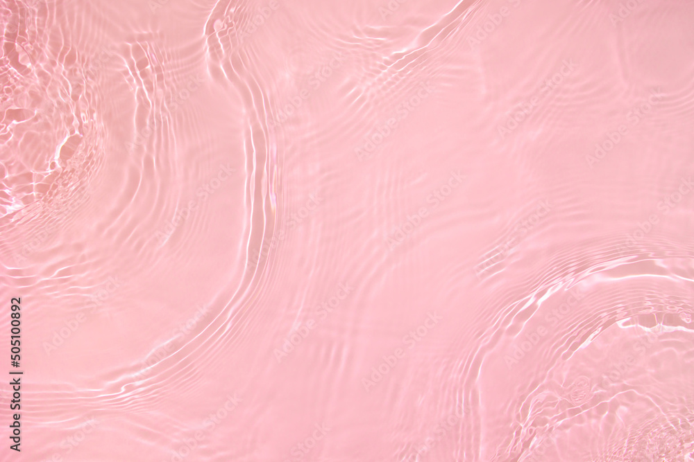 Fototapeta premium Transparent pink colored clear water surface texture with ripples, splashes and bubbles. Abstract nature background Water waves in sunlight with copy space Cosmetic moisturizer micellar toner emulsion