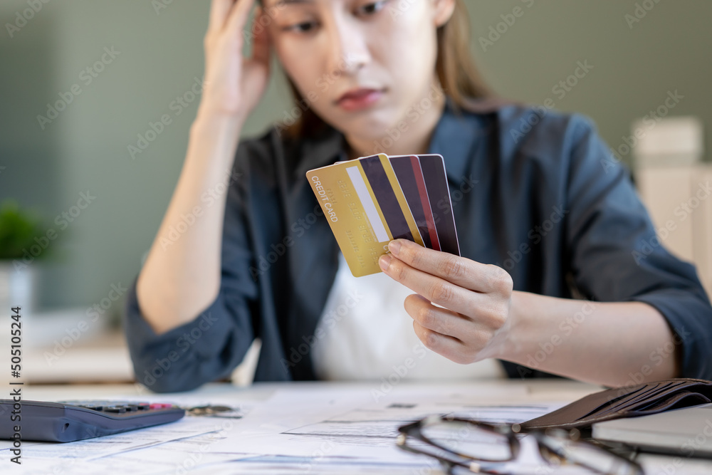 Financial owe, hand of asian woman sitting, holding many credit card, stressed by calculate expense from invoice or bill, no money to pay, mortgage or loan. Debt, bankruptcy or bankrupt Financial owe, hand of asian woman sitting, holding many credit card, stressed by calculate expense from invoice or bill, no money to pay, mortgage or loan. Debt, bankruptcy or bankrupt