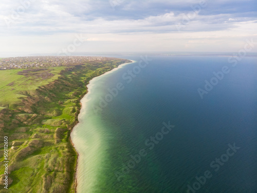 Aerial view of surreal coastline with unreal terrain hills near calm green water sea estuary
