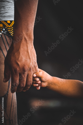 Indian father and son holding hands