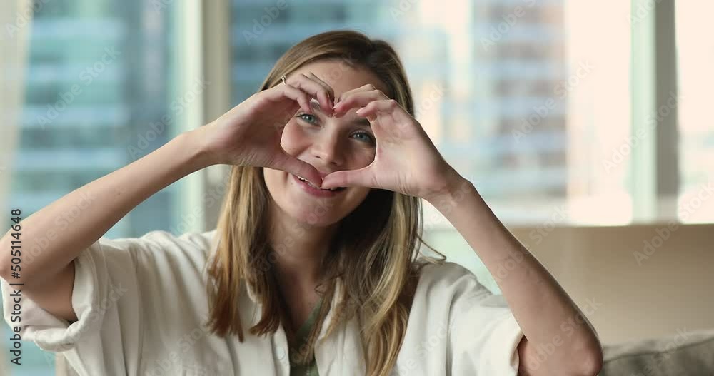 Head shot close up portrait happy woman showing heart shape gesture with fingers, make love sign smile looks at camera. E-dating services, donation campaign, loyalty, express sincere feelings concept Head shot close up portrait happy woman showing heart shape gesture with fingers, make love sign smile looks at camera. E-dating services, donation campaign, loyalty, express sincere feelings concept