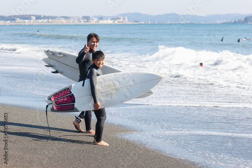 湘南の海でサーフィンをする親子