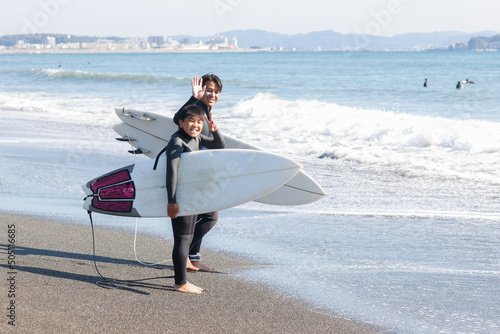 湘南の海でサーフィンをする親子