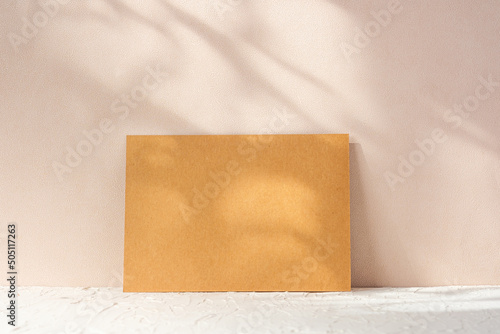blank kraft paper poster with pampass grass in wood vase on cement table at peach wall