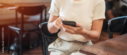 Casual Businesswoman holding and using smartphone for sms messages, young woman typing touchscreen mobile phone in cafe or modern office. lifestyle, technology, Social media and network concept