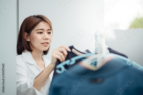An Asian housewife is drying clothes on the rack after washing.
