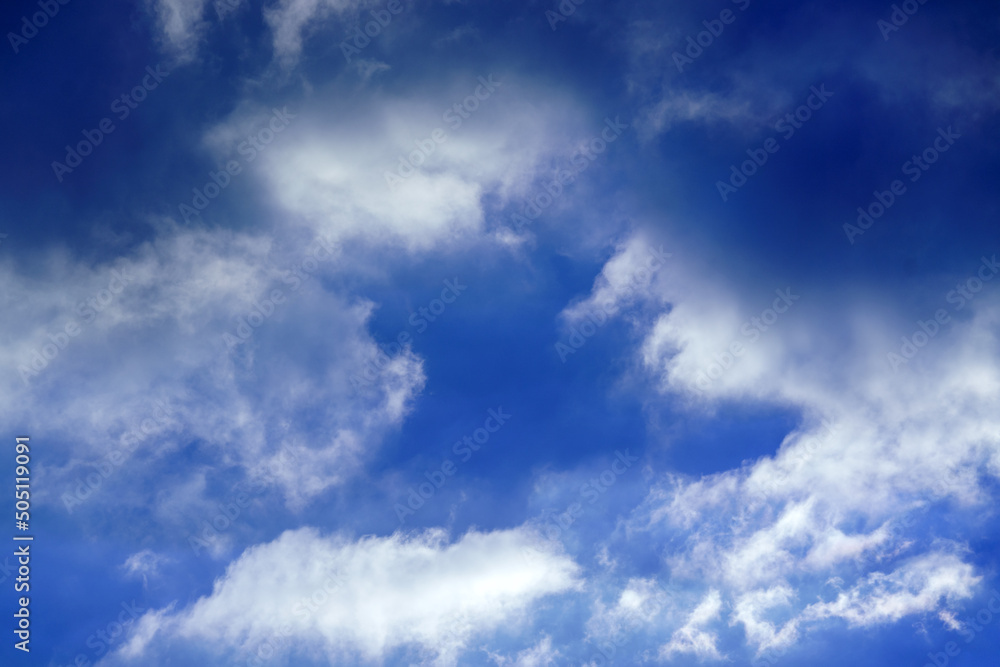 Fototapeta premium Summer sky. Heaven and infinity. Beautiful bright blue background. Light cloudy, good weather. White clouds in the blue sky. Curly clouds on a sunny day